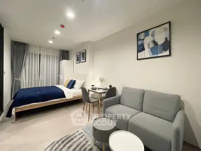 Modern studio apartment with stylish decor, featuring a cozy bed, chic sofa, and elegant dining area.