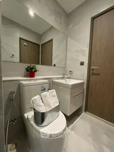 Modern bathroom with sleek fixtures and elegant design, featuring a compact layout and stylish finishes.