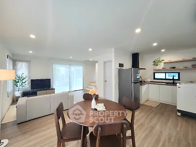 Modern open-plan living room and kitchen with stylish furniture and natural light.
