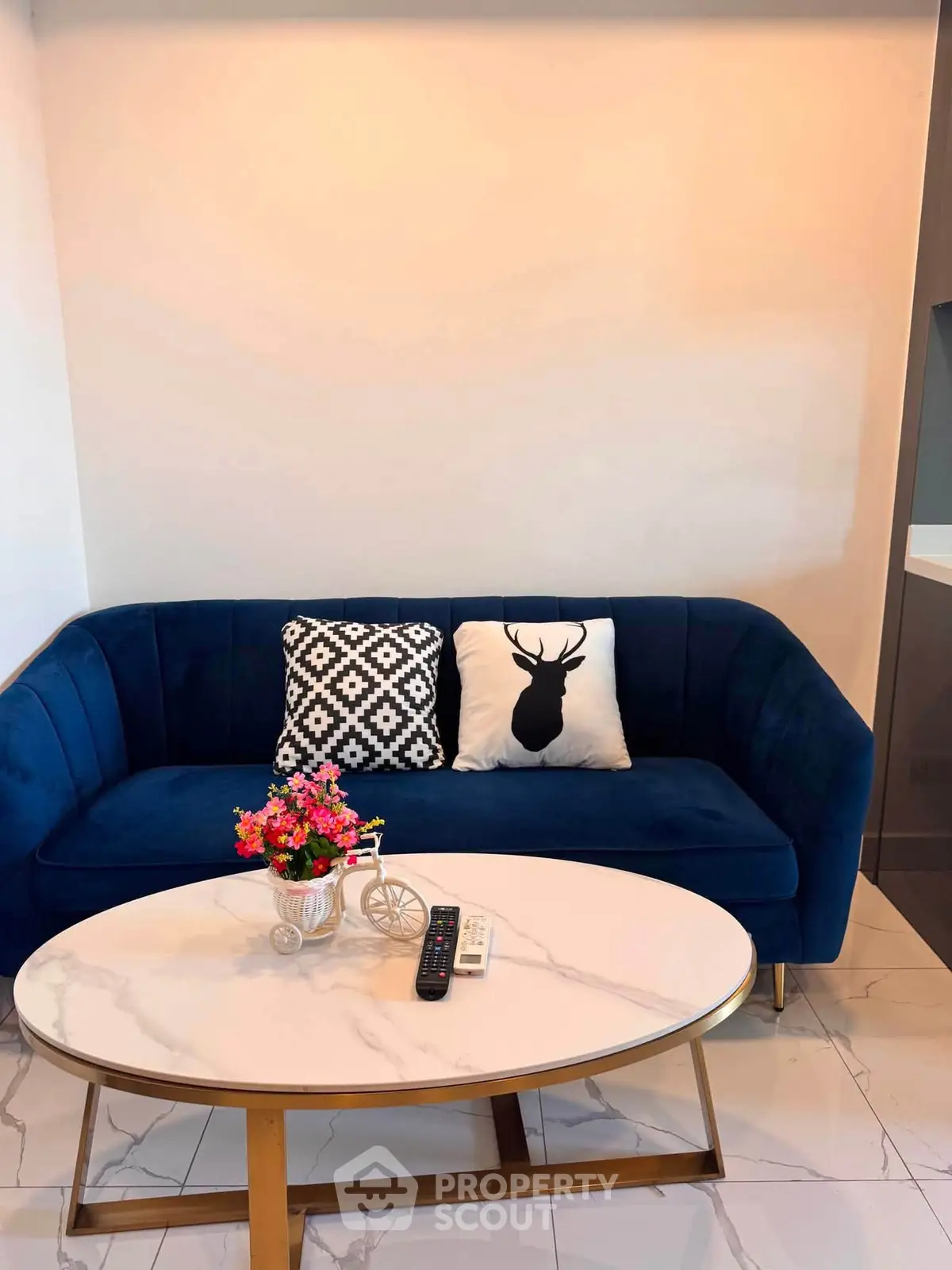 Stylish living room with modern blue sofa and elegant coffee table, perfect for cozy gatherings.