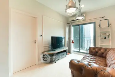 Stylish living room with leather sofa and balcony access in modern apartment.