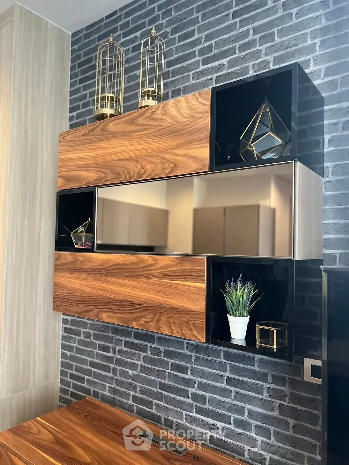 Modern interior with stylish wooden shelving and decorative accents on a brick wall.