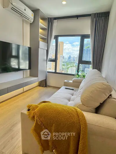 Modern living room with city view, cozy sofa, and wall-mounted TV in a high-rise apartment.