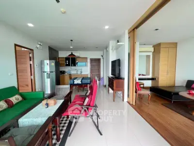 Spacious open-plan living room with modern kitchen and sliding doors to bedroom.
