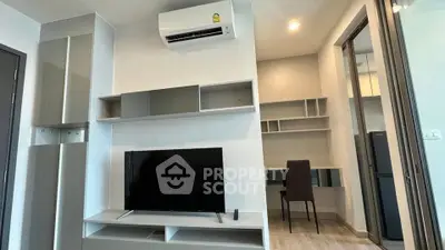Modern living room with sleek TV unit and air conditioning, adjacent to a study area.