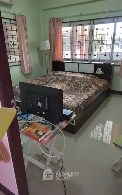 Cozy bedroom with large bed and window view, perfect for relaxation.