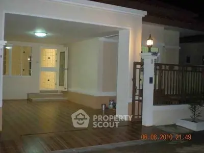 Charming exterior view of a well-lit house entrance with spacious driveway.