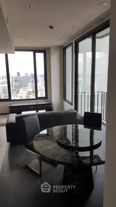 Modern living room with city view and stylish black marble dining table.