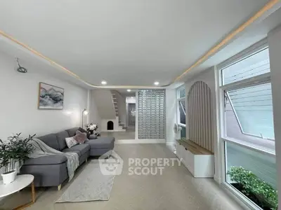 Spacious modern living room with stylish decor and large windows for natural light.