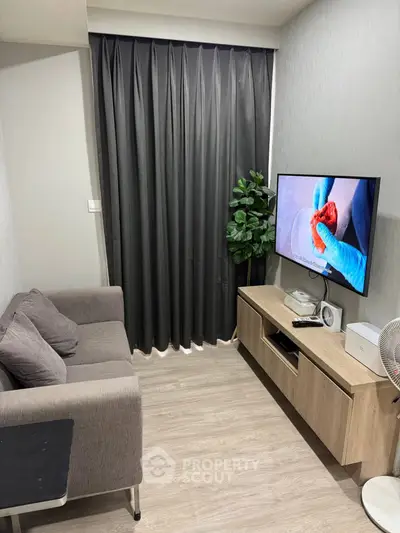 Cozy living room with modern decor, featuring a comfortable sofa, flat-screen TV, and stylish wooden cabinet.