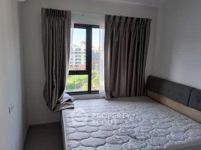 Cozy bedroom with large window and modern curtains, offering a bright and inviting atmosphere.