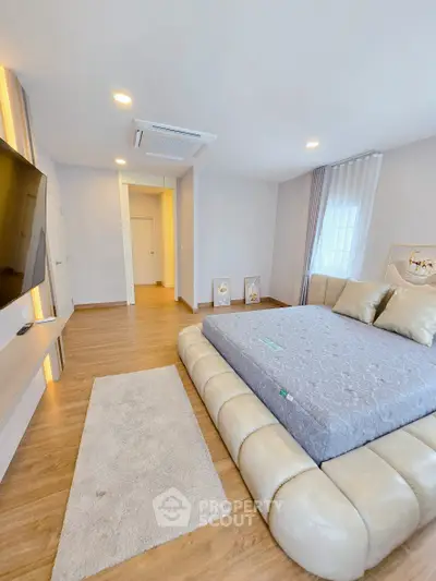 Luxurious modern bedroom with stylish decor and plush bed in a spacious setting.