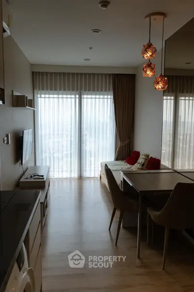 Modern living room with stylish lighting and large windows in a cozy apartment.