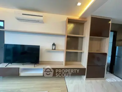 Modern living room with sleek TV unit and air conditioning, featuring stylish shelving and contemporary design.