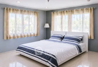 Spacious bedroom with large windows and modern decor, perfect for relaxation and comfort.
