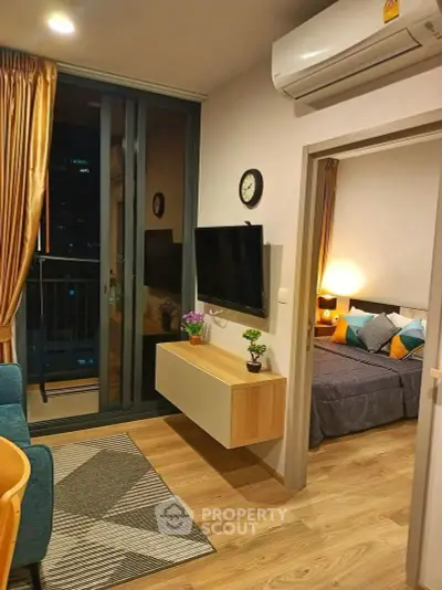 Modern apartment interior with cozy living room and stylish bedroom, featuring wooden flooring and elegant decor.