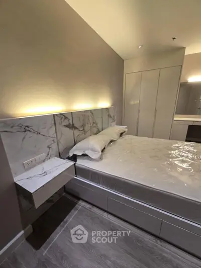 Modern bedroom with elegant marble accents and built-in storage in a luxury apartment.