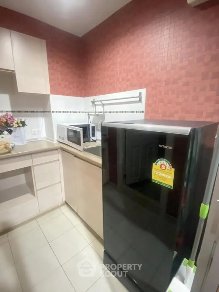 Modern kitchen with sleek appliances and stylish red accent wall