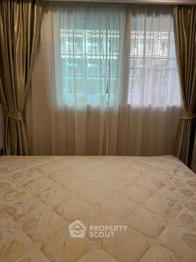 Cozy bedroom with elegant curtains and a comfortable bed, perfect for relaxation.