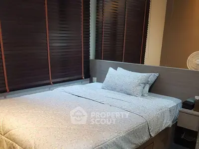 Cozy bedroom with modern blinds and comfortable bedding in a stylish apartment.
