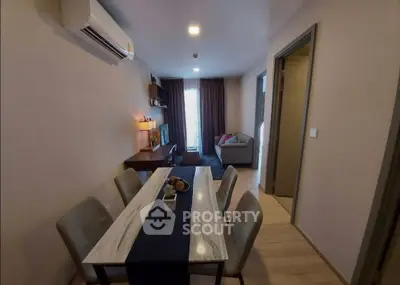 Modern dining area with stylish table and cozy living room in open layout apartment.