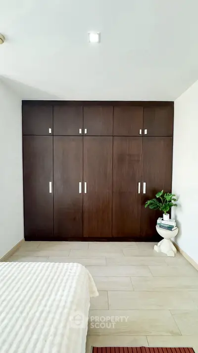 Spacious bedroom with elegant wooden wardrobe and cozy decor