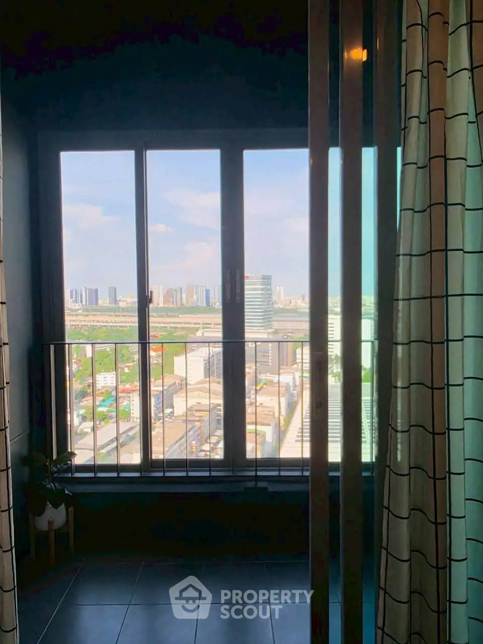 Stunning high-rise view from a modern apartment window, showcasing city skyline and natural light.
