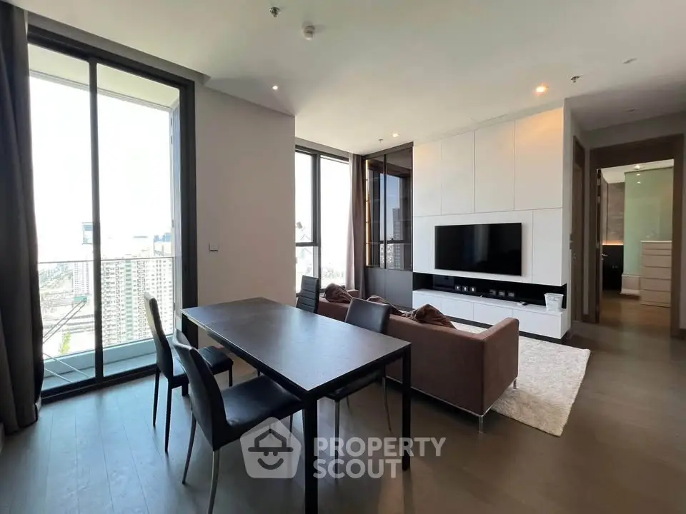 Modern living room with city view, sleek furniture, and open layout in high-rise apartment.