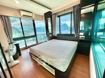 Spacious bedroom with large windows and modern furnishings, offering abundant natural light and scenic views.