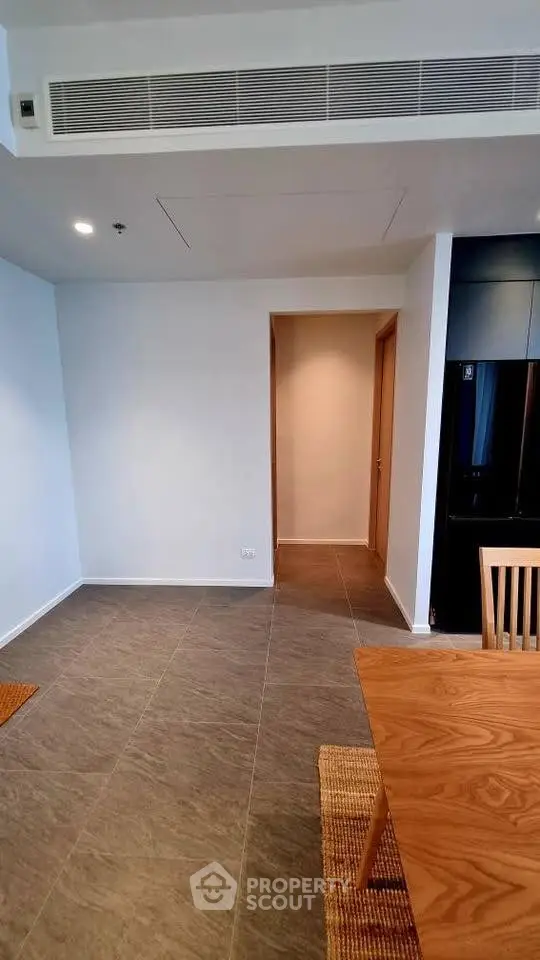 Modern apartment interior with sleek dining area and tiled flooring, showcasing minimalist design.