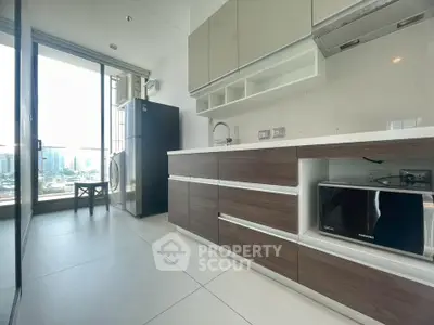 Modern kitchen with sleek cabinetry, city view, and built-in appliances in a high-rise apartment.