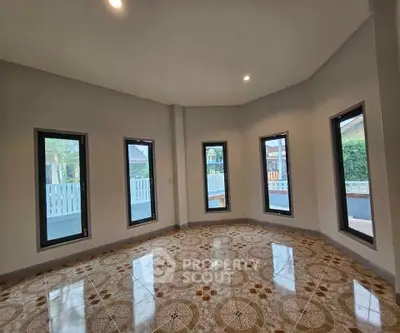 Spacious room with large windows and decorative tiled flooring
