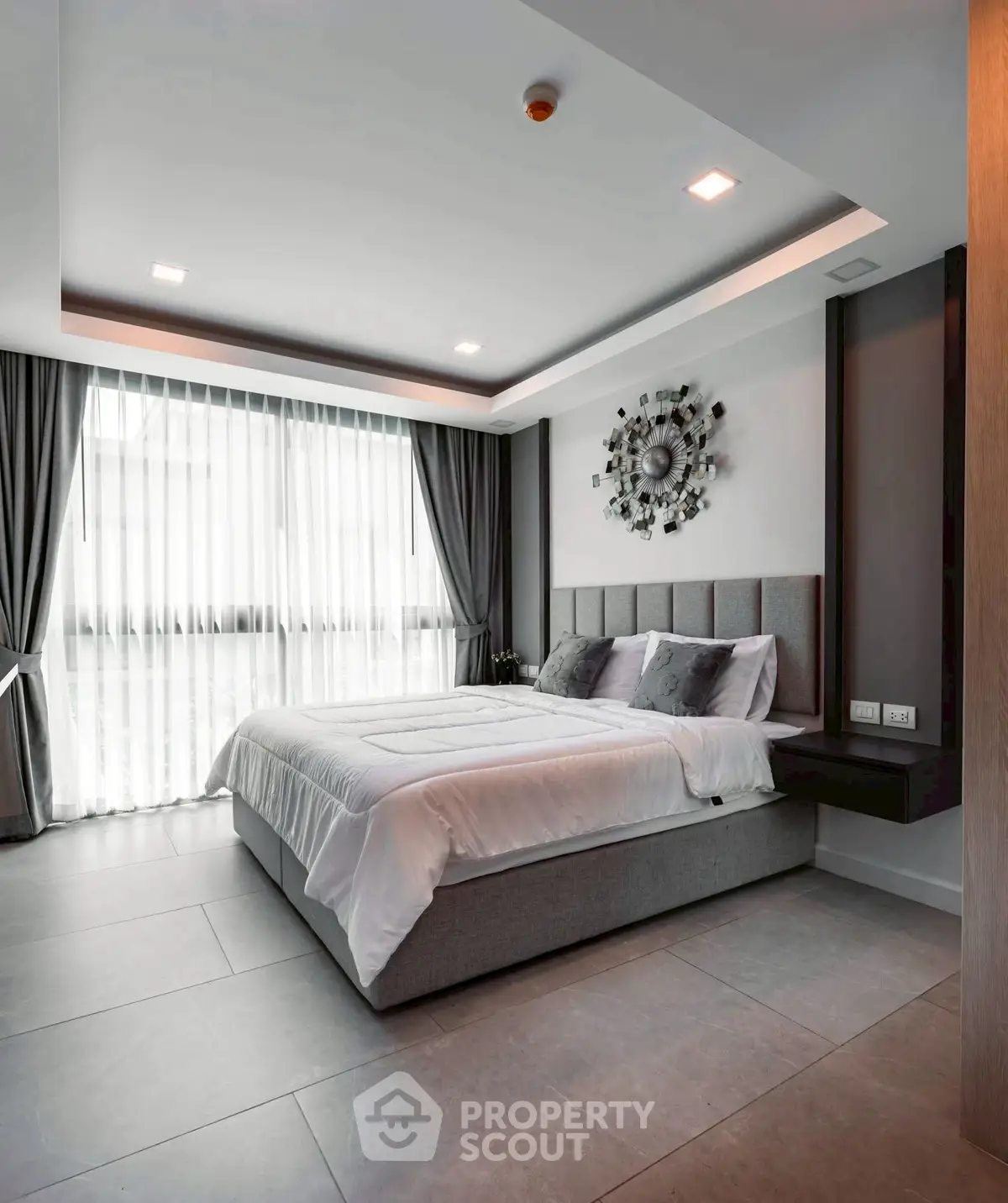 Modern bedroom with stylish decor and large window for natural light