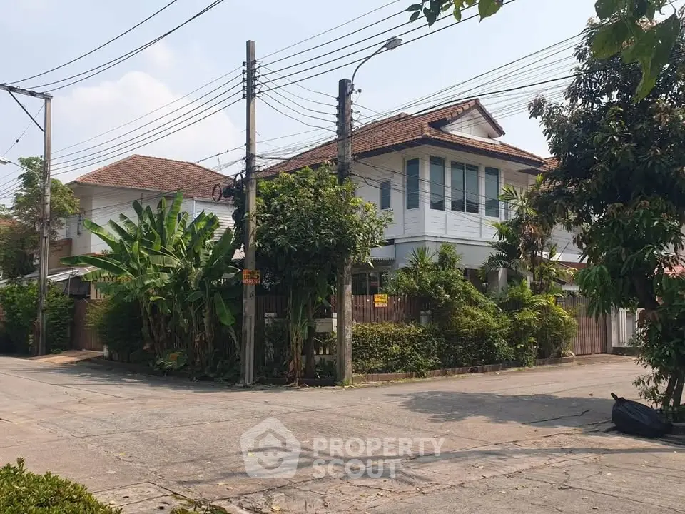 Charming suburban house with lush greenery and spacious corner lot.