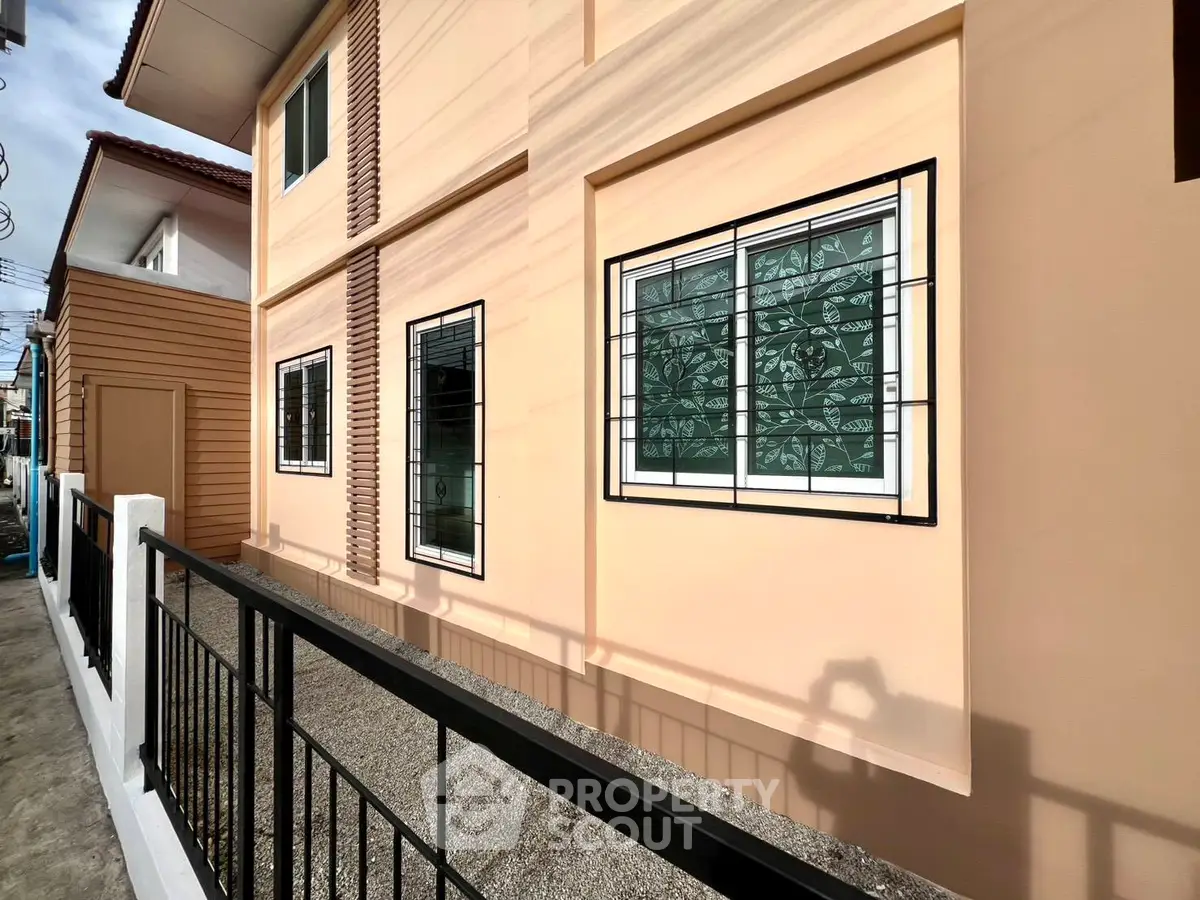 Modern residential building exterior with stylish window grills and sleek design.