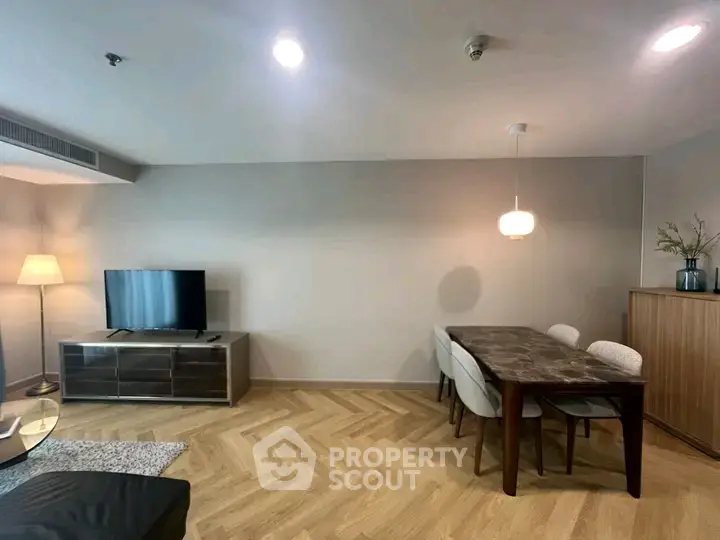 Modern living room with stylish dining area and elegant wooden flooring.