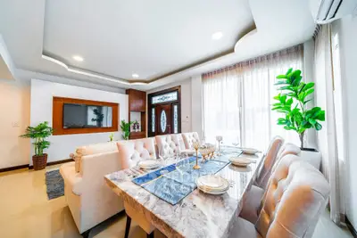 Luxurious dining area with elegant table setting and plush seating in a modern home.