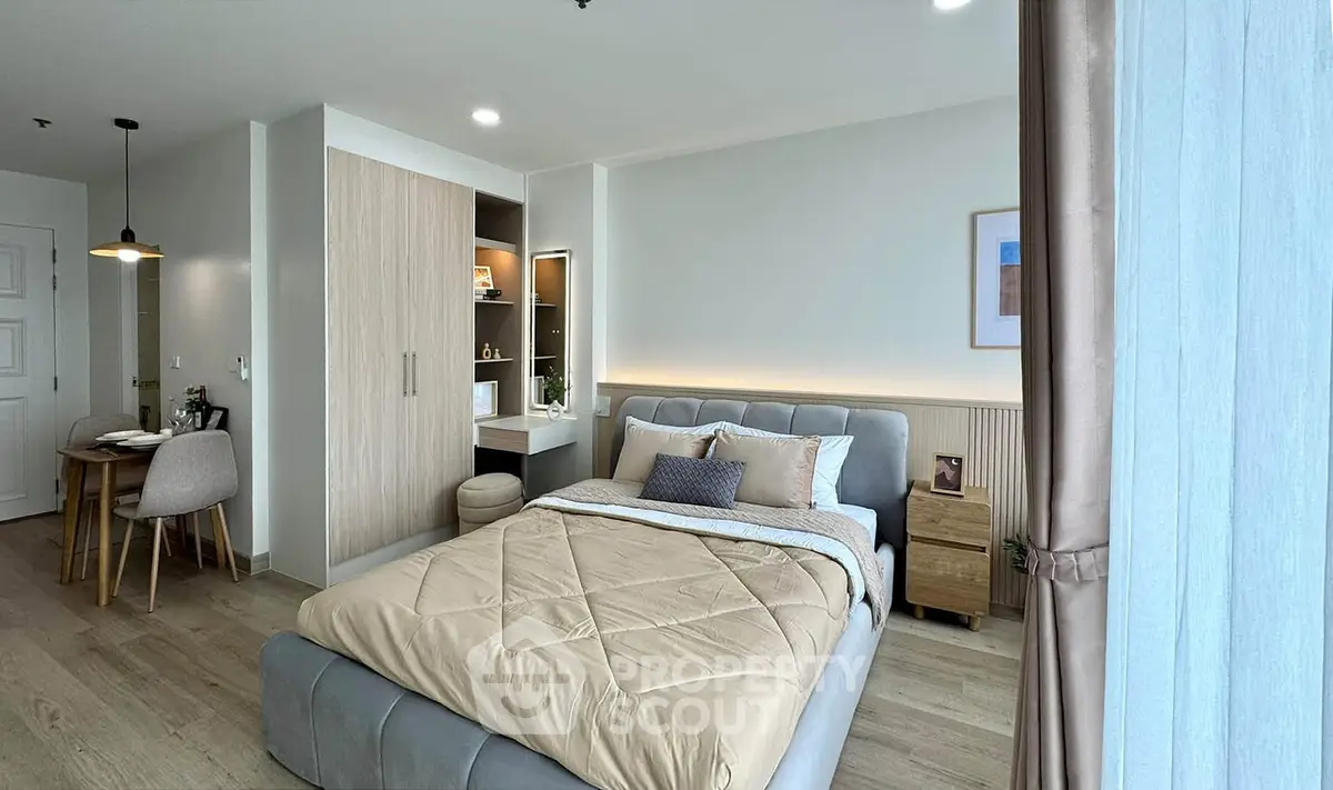 Modern bedroom with stylish decor and natural light, featuring a cozy bed and elegant furnishings.