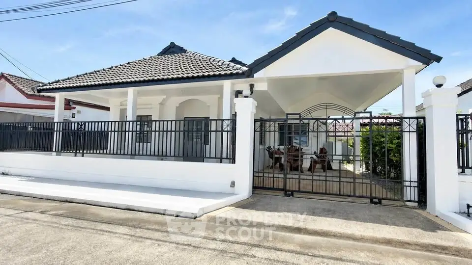 Charming single-story home with gated entrance and tiled roof in a serene neighborhood.