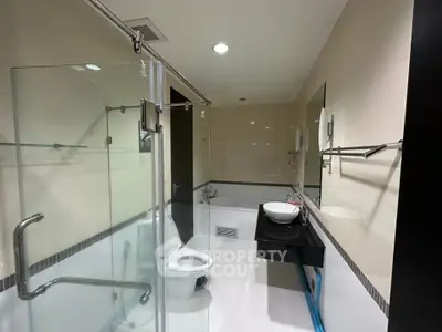 Modern bathroom with glass shower and sleek fixtures in a contemporary home.