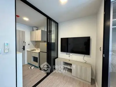 Modern compact living room with TV and open kitchen layout