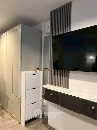 Modern living room with sleek TV setup and stylish storage solutions.