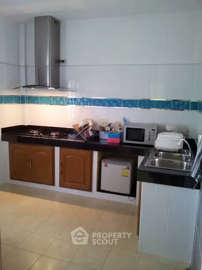 Modern kitchen with sleek black countertops, stainless steel appliances, and stylish cabinetry.
