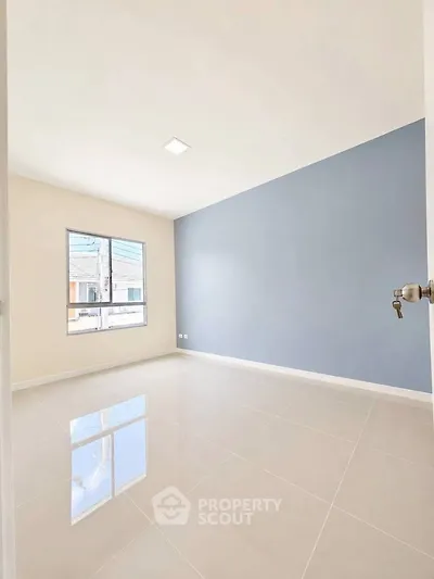 Spacious empty room with large window and glossy tiled floor, perfect for customization.