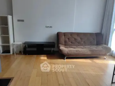 Spacious living room with modern sofa and wooden flooring, perfect for cozy living.