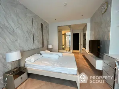 Luxurious bedroom with marble walls, sleek furnishings, and access to a private balcony, exuding modern elegance and comfort.