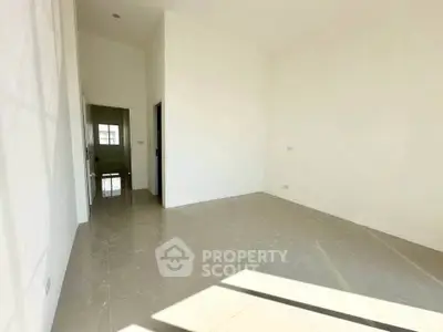 Spacious empty room with glossy tiled floor and bright natural light