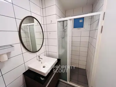 Modern bathroom with sleek shower and stylish vanity in a compact space.