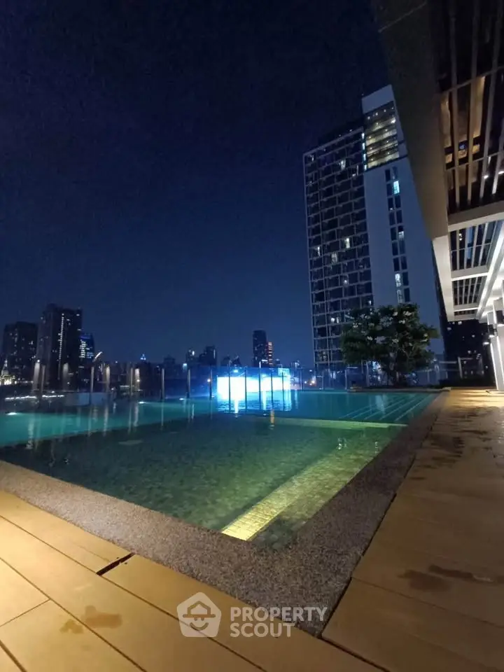 Stunning rooftop pool with city skyline view at night, perfect for luxury living.