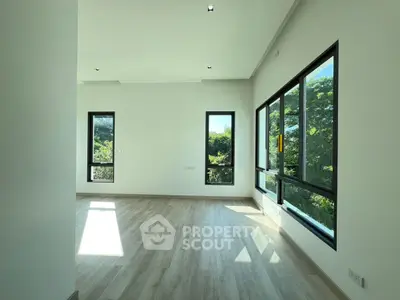 Spacious and bright room with large windows and scenic views, perfect for modern living.